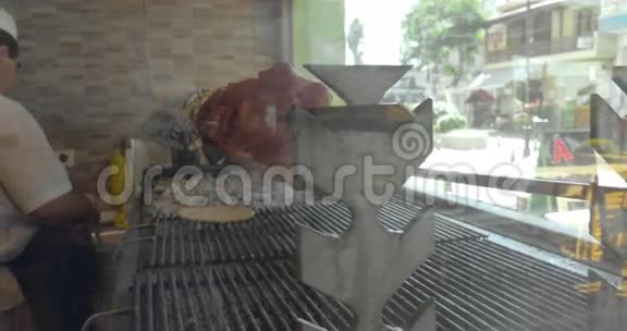 厨师在橱窗旁的咖啡馆里做烤鸡皮塔和烤肉视频的预览图