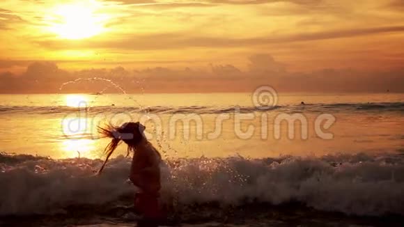 夕阳中的女孩从水中飞溅视频的预览图