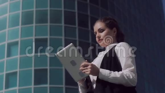 在户外制作平板电脑的皮肤白皙魅力十足的商务女性视频的预览图