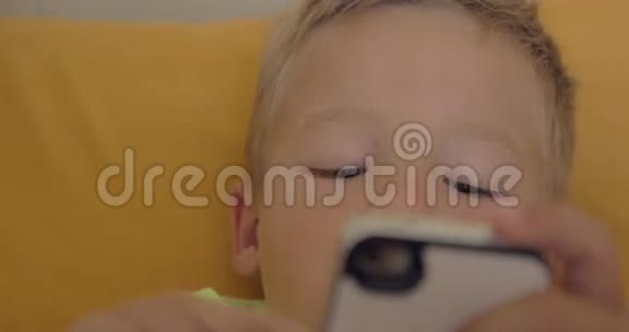小男孩在智能手机上玩游戏的特写镜头视频的预览图