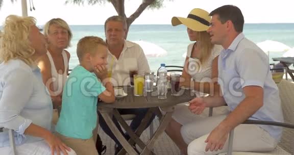 希腊佩雷亚市海边的一大家子坐在餐桌旁视频的预览图