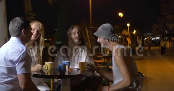 一群快乐的朋友晚上坐在街头咖啡馆里所有的粘糊糊的杯子然后其中一个人提出视频的预览图