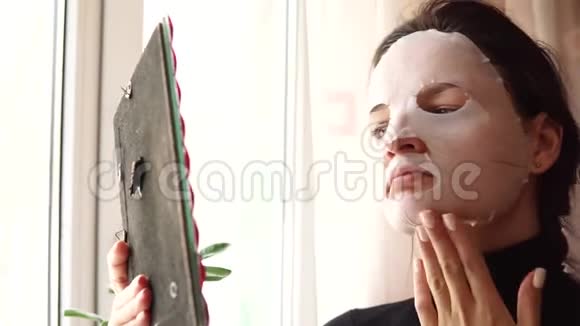 年轻女子正在做面膜片脸上戴着净化面具视频的预览图