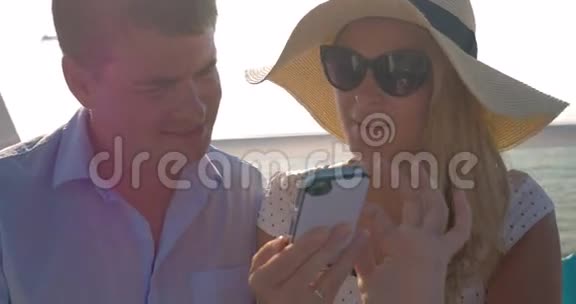 在阳光明媚的一天里希腊的一对年轻夫妇乘坐着一艘小船视频的预览图