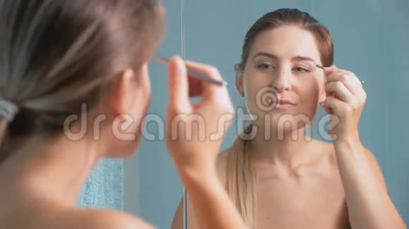 4K镜头美丽的黑发女人用镊子塑造她的眉毛视频的预览图
