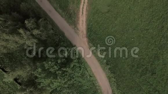 在绿色的田野上飞过乡间小路视频的预览图