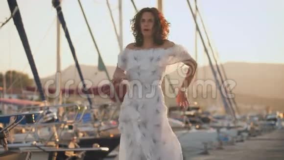 夏日里美丽的女人在码头上跳舞视频的预览图