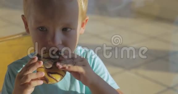 男孩吃巧克力甜甜圈和饮用水视频的预览图