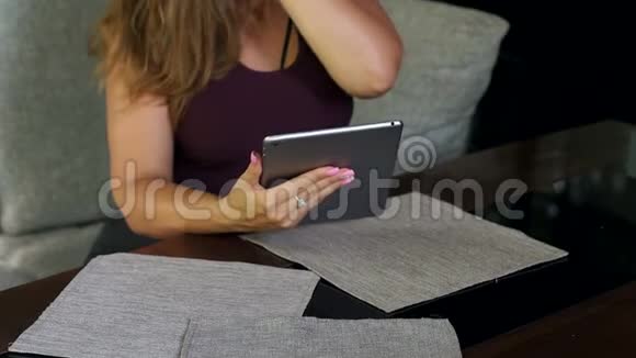 体重超标的女孩坐在有平板电脑的咖啡馆里视频的预览图
