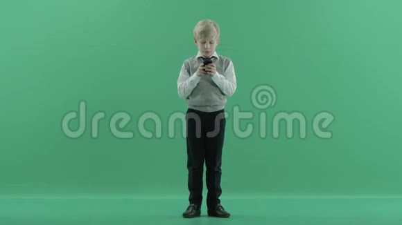 男生在绿色屏幕背景下使用手机视频的预览图