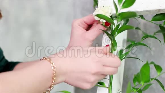 花卉艺术家用绿色植物和花卉装饰白色木制楼梯植物装饰理念视频的预览图