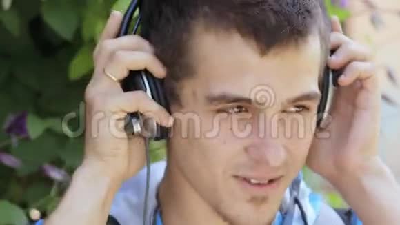 带着耳机在户外欣赏音乐的年轻人视频的预览图