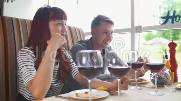 餐馆里的朋友年轻的男人和女人聊天喝酒视频的预览图