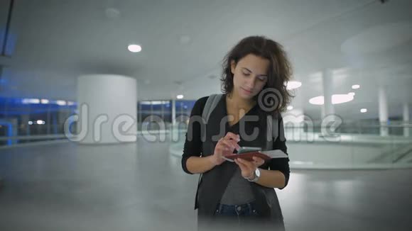一位年轻漂亮的女士正在旅行前用她的手机检查新手机视频的预览图