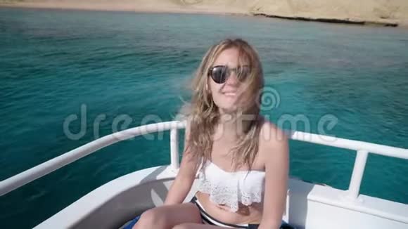 一个年轻漂亮的白种人女人在游艇上穿比基尼和太阳镜的肖像假期自由的概念视频的预览图