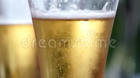 在装有水滴的玻璃杯里放冷光啤酒啤酒泡泡慢动作视频的预览图