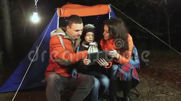 小幸福一家在帐篷的背景下在森林里自拍视频的预览图
