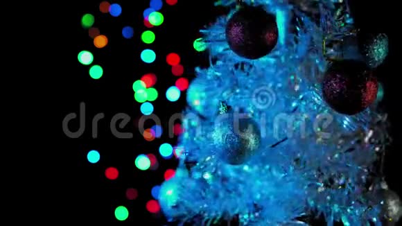 白色人造圣诞树带球旋转在黑色背景上视频的预览图