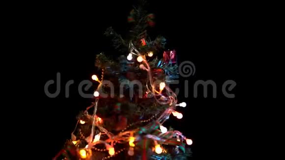 彩灯和玩具的圣诞树在黑色背景上旋转视频的预览图