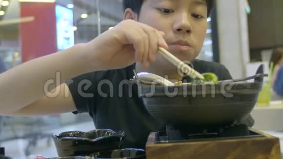 慢动作的亚洲可爱男孩喜欢吃日本食物微笑的脸视频的预览图