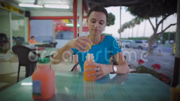 坐在餐馆里喝橙汁的女人视频的预览图