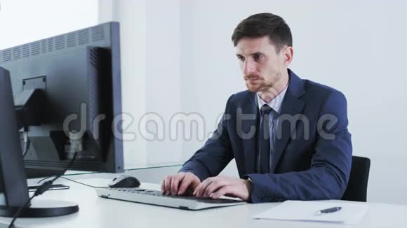 年轻的商人用一台固定的电脑工作视频的预览图