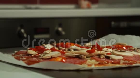 厨师把奶酪放在生皮披萨的特写上视频的预览图