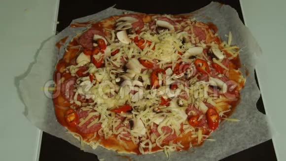 厨师把奶酪放在生皮披萨的特写上视频的预览图