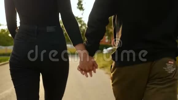 一对年轻的男女在夏天走在桥上日落的光时尚快乐的一对牵手约会视频的预览图