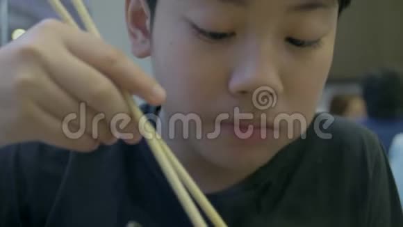 慢动作的亚洲可爱男孩喜欢吃日本食物微笑的脸视频的预览图