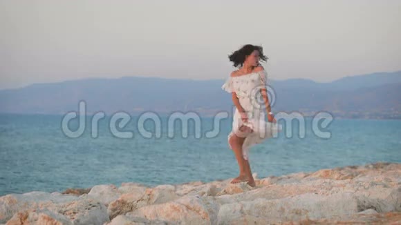 一位穿着裙子在岩石上跳舞的年轻美女视频的预览图