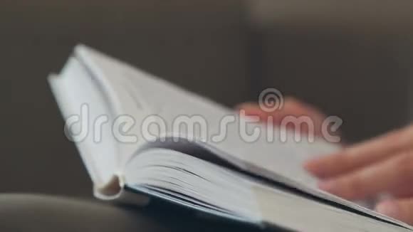 一个女人的手翻过书的每一页视频的预览图