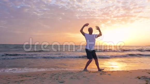 早上日出时男子练太极拳海上沙滩视频的预览图