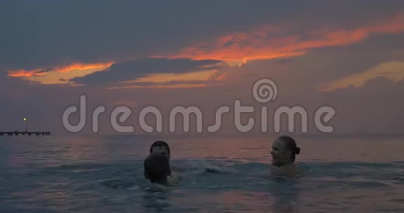 日落时分母亲父亲和儿子在希腊的佩雷亚市的海上游泳视频的预览图
