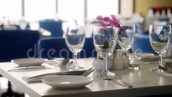 复习大厅用装饰的桌子餐具在餐厅用鲜花装饰婚礼慢动作视频的预览图