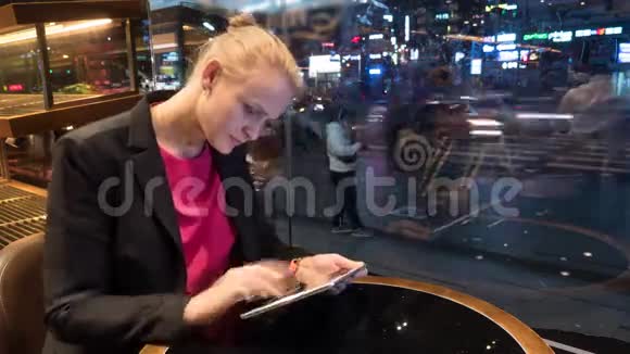 在城市背景上使用触摸板坐在咖啡馆的女人的时间流逝镜头韩国首尔视频的预览图
