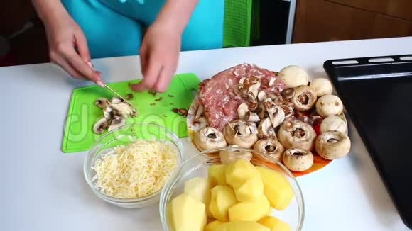 一个女人在切割板上切了新鲜的香瓜桌子旁边有极好的土豆烤盘多汁的切碎机和切碎机视频的预览图