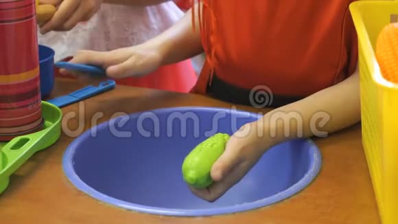 小女孩清洗人造绿色黄瓜视频的预览图