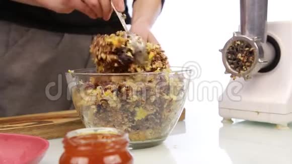 妇女在坚果黄油中加入蜂蜜并在碗中混合配料视频的预览图