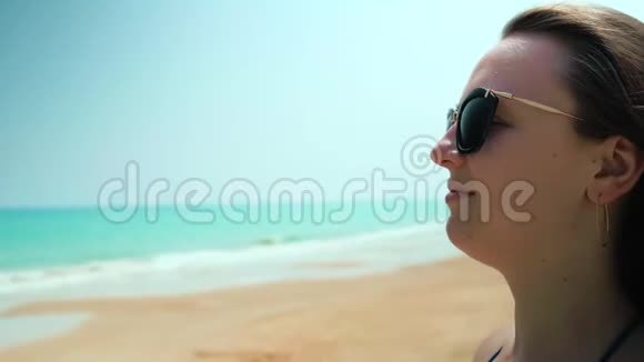 海滩上的年轻女孩调整她的头发近距离射击视频的预览图