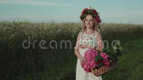 一个头上戴着花篮和花圈的女孩走在田野里视频的预览图