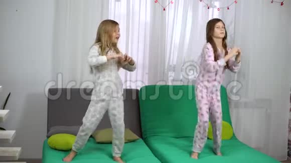 两个穿睡衣的可爱女孩在沙发上跳舞视频的预览图