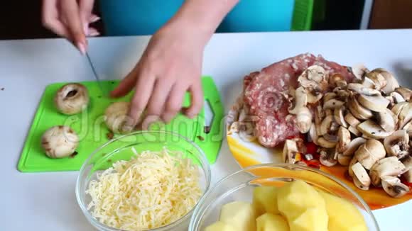 一个女人在切割板上切了新鲜的香瓜桌子旁边有极好的土豆烤盘多汁的切碎机和切碎机视频的预览图