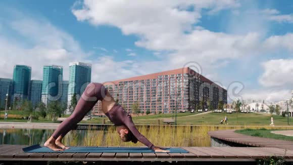 年轻女子做瑜伽运动与城市背景放松和自由的概念视频的预览图