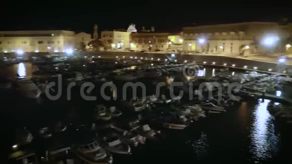 4k快速夜航无人机帆船港和沿海城镇的镜头视频的预览图