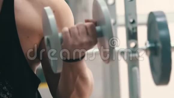 在健身房锻炼二头肌的年轻人视频的预览图