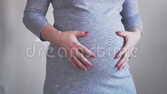 靠近孕妇抱着她的小肚子她的丈夫来拥抱她拥抱她抚摸她肿胀的腹部视频的预览图