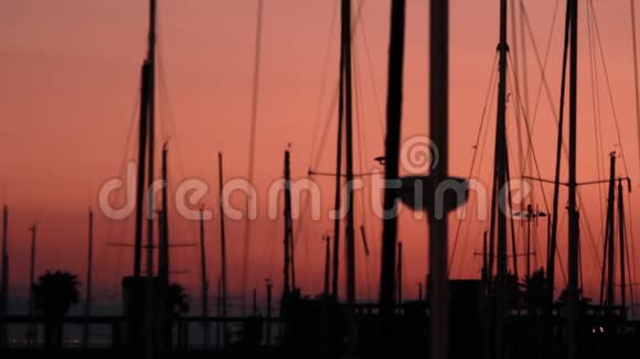 游艇的剪影背景黄昏日落在海上游艇港和船桅视频的预览图