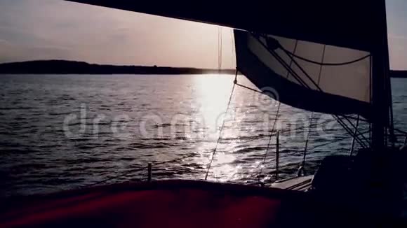美丽的游艇在日落时穿过大海帆板在晚上全速穿过湖面上的波浪视频的预览图