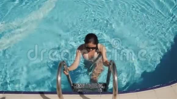 有魅力的年轻女性走出游泳池户外的肖像视频的预览图